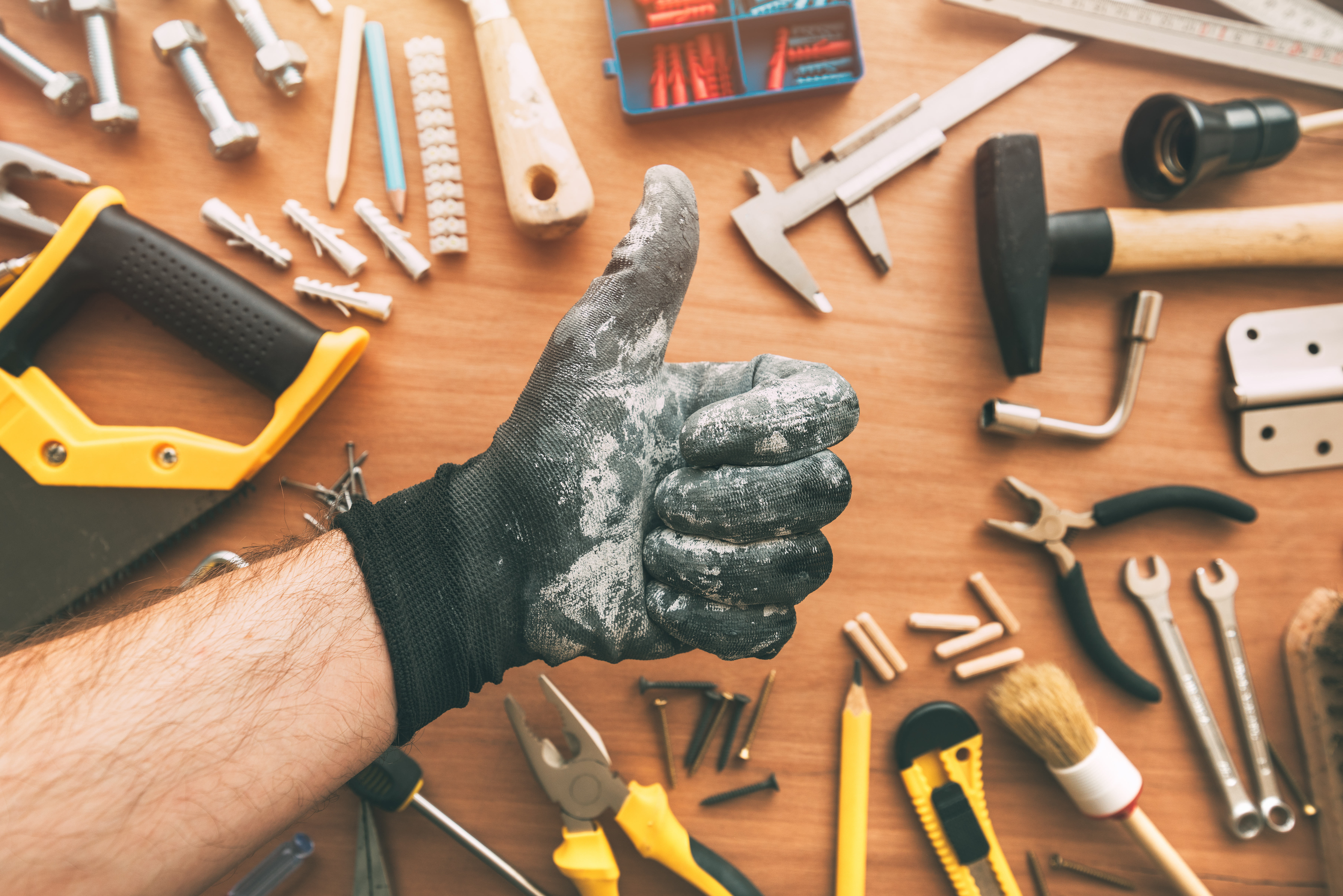 Handyman gesturing thumb up as confirmation hand sign, top view